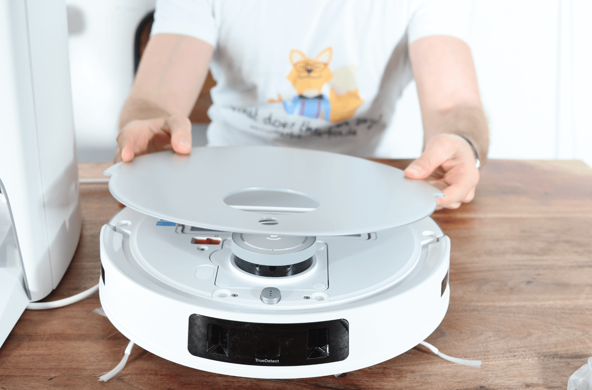 Der magnetische Deckel des ECOVACS DEEBOT T20 OMNI wird abgenommen.